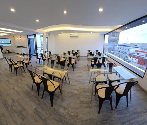 un restaurante con mesas y sillas y una gran ventana en Hotel Regata, en Iquique