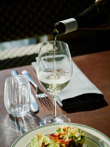 a glass of wine being poured into a plate of food at Holiday Inn & Suites Geelong by IHG in Geelong
