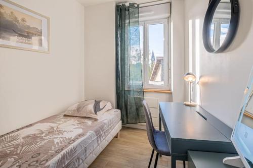 Un dormitorio con una cama, un escritorio y una mesa. en Le Magnifique T3, en Limoges