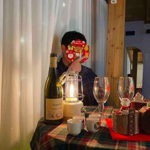 a person sitting at a table with a bottle of wine at Onheim in Tongyeong