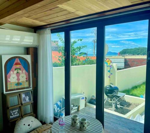 a room with a view of a balcony with a table at Onheim in Tongyeong