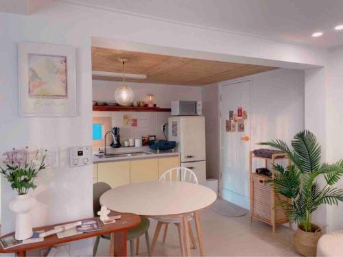 a kitchen with a table and chairs in a room at Onheim in Tongyeong