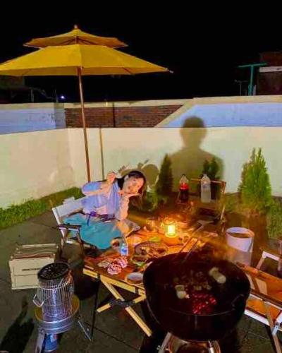 a woman sitting at a table with an umbrella at Onheim in Tongyeong