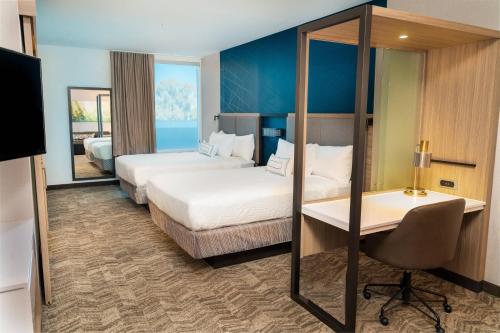 a hotel room with two beds and a desk at SpringHill Suites by Marriott Newark Fremont in Newark
