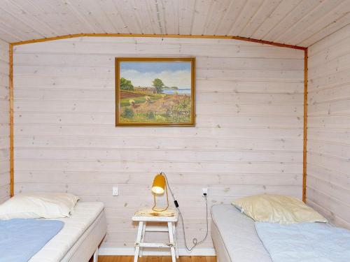 a bedroom with two beds and a picture on the wall at Holiday home Farsø VIII in Farsø