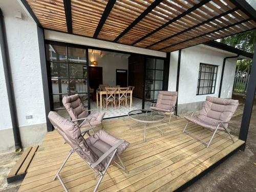 eine Terrasse mit Stühlen und einem Tisch auf einer Terrasse in der Unterkunft El Diamante Campestre in Medellín