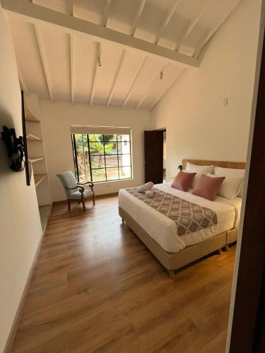 ein Schlafzimmer mit einem Bett und einem Stuhl in der Unterkunft El Diamante Campestre in Medellín