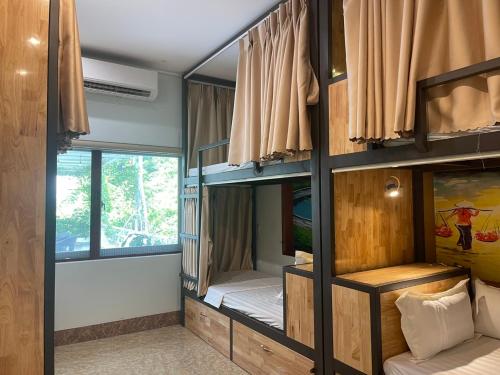 Tam Coc Guest House & Hostel في نينه بينه: غرفة مع ثلاثة أسرة بطابقين مع نافذة