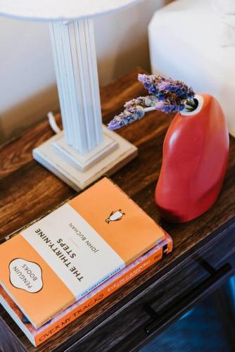 a table with a book and a vase on a table at 'Wilpine' Poolside Country Luxury near Town in Mudgee