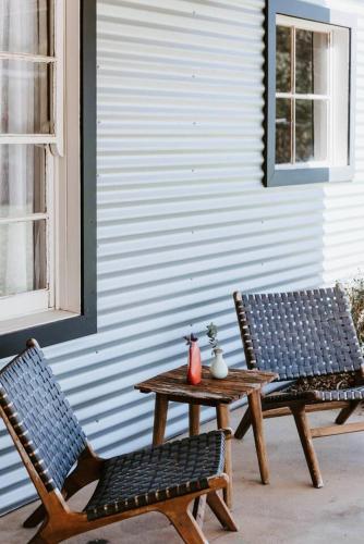 two chairs and a table with a table and two benches at 'Wilpine' Poolside Country Luxury near Town in Mudgee