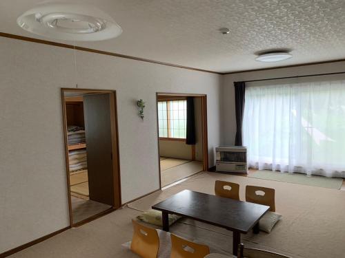 a living room with a table and a window at FURANO UEDA HOUSE in Furano
