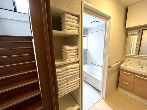 bagno con cabina armadio e asciugamani di Naos House Osaka 4 New Open 一軒家貸切 ad Osaka