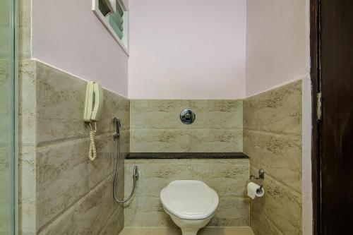 een badkamer met een toilet en een telefoon bij Pphliving Fortune suites in Bangalore