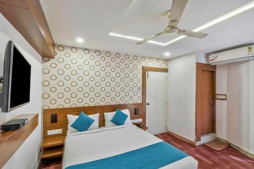 een slaapkamer met een bed, een bureau en een televisie bij Pphliving Fortune suites in Bangalore