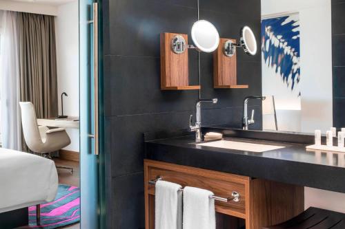 a bathroom with a sink and a mirror at Le Méridien Nouméa Resort & Spa in Noumea