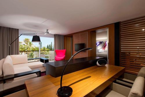 a living room with a desk with a lamp on it at Le Méridien Nouméa Resort & Spa in Noumea