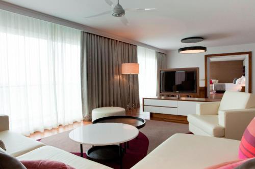 a living room with a couch and a tv in a room at Le Méridien Nouméa Resort & Spa in Noumea