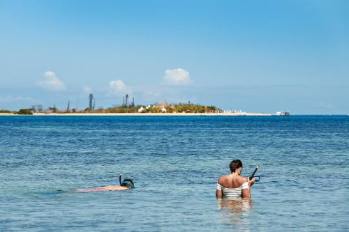 a woman in the water next to a man in the ocean at Le Méridien Nouméa Resort & Spa in Noumea