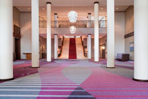 a hallway with columns and a staircase in a building at Le Méridien Nouméa Resort & Spa in Noumea