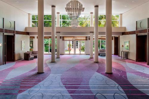 a large lobby with columns and a chandelier at Le Méridien Nouméa Resort & Spa in Noumea