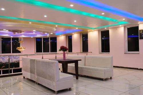 a conference room with a table and white chairs at Pink Park by Panache Hotels in Bīr