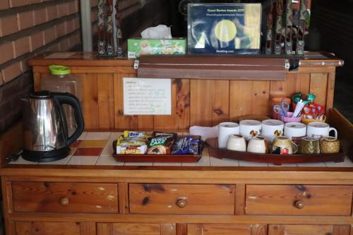 a wooden dresser with food and drinks on it at Phumthada Rommanee Krabi Resort in Ban Khlong Khanan