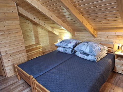 1 dormitorio con 1 cama en una cabaña de madera en Domki Nad Liliowym Stawem, en Berezka