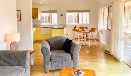 a living room with a chair and a table at Poinciana Cottages in Burnt Pine