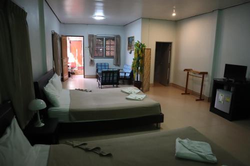 a room with two beds and a living room at Phumthada Rommanee Krabi Resort in Ban Khlong Khanan