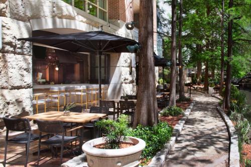 a patio with a table and chairs and an umbrella at The Westin Riverwalk, San Antonio in San Antonio