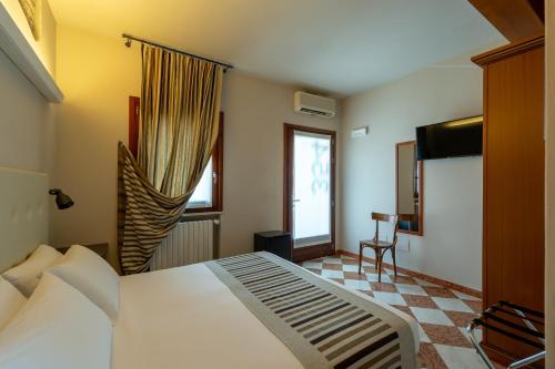 Un dormitorio con una gran cama blanca y una ventana en A Casa Dei Gonzaga, en Mantua