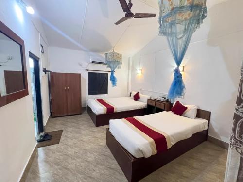 a hotel room with two beds and a couch at Ama Garden Sauraha in Sauraha