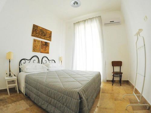 een slaapkamer met een bed, een stoel en een raam bij B&B Liberty in Andria
