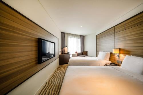 GimpoにあるHotel Marinabay Seoulのベッド2台、薄型テレビが備わるホテルルームです。