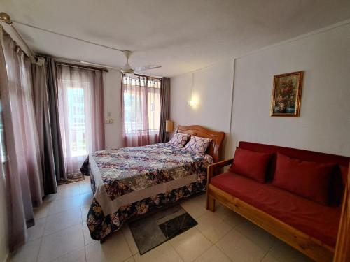 a bedroom with a bed and a couch at Bano Beach Residence - Grand Bay Beach in Grand-Baie
