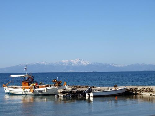 three boats are docked on the shore of the water at Entire cottage near the beach in Nimporio, Euboea in Nimporio