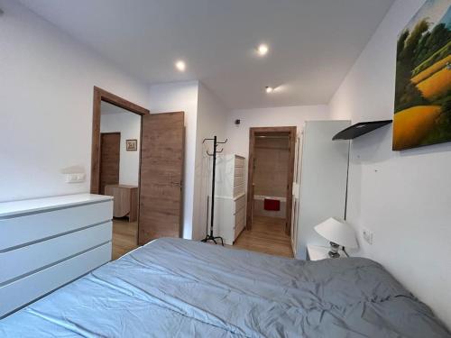 - une chambre avec un lit, une commode et un miroir dans l'établissement Piso Castelló d'Empúries, à Castelló d'Empúries