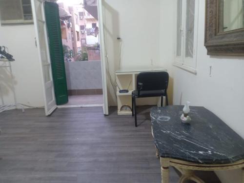 Zimmer mit einem Tisch, einem Stuhl und einer Tür in der Unterkunft Baronz Car in Kairo