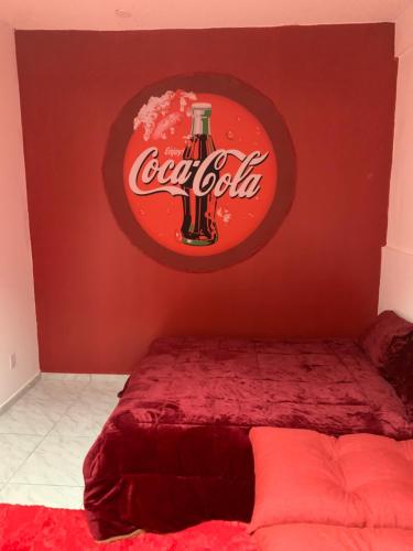 a bedroom with a cocacola sign on the wall at Loft Coca-Cola Passo Fundo in Passo Fundo