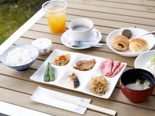 a table with plates of food and a cup of orange juice at Hakone Yumoto hotel in Hakone