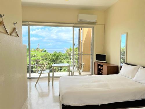 a bedroom with a bed and a view of a balcony at Blue cave Blue in Green - Vacation STAY 31651v in Fukai