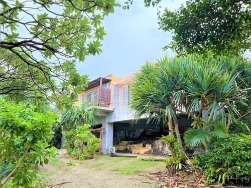 uma casa com palmeiras em frente em Blue cave Blue in Green - Vacation STAY 31651v em Fukai