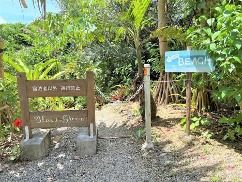 um sinal para uma praia e um sinal para uma rua em Blue cave Blue in Green - Vacation STAY 31651v em Fukai