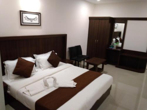 a hotel room with a bed with towels on it at Highrange Plaza in Thekkady