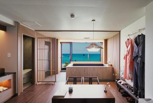 a bathroom with a tub and a view of the ocean at Gyeongju Denbasta Ryokan in Gyeongju