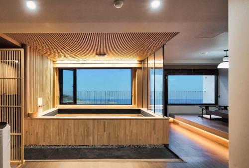 Cette chambre dispose d'une grande fenêtre offrant une vue sur l'océan. dans l'établissement Gyeongju Denbasta Ryokan, à Gyeongju