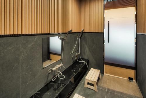 a bathroom with a sink and a mirror and a bench at Gyeongju Denbasta Ryokan in Gyeongju