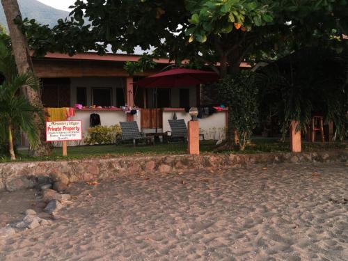 a house on the beach with a sign in front of it at Marianita's cottages in Mambajao