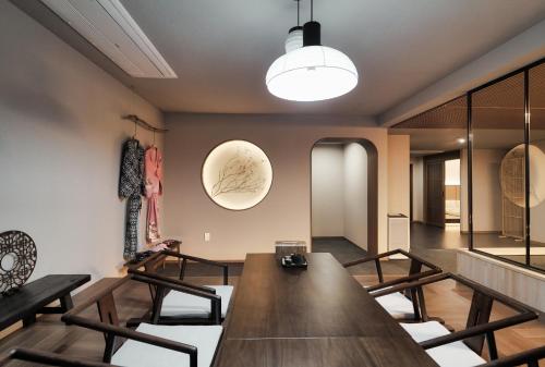 a dining room with a large wooden table and chairs at Gyeongju Denbasta Ryokan in Gyeongju