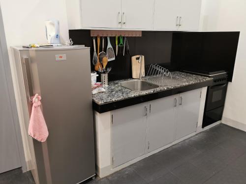 a kitchen with a refrigerator and a sink at Marianita's cottages in Mambajao